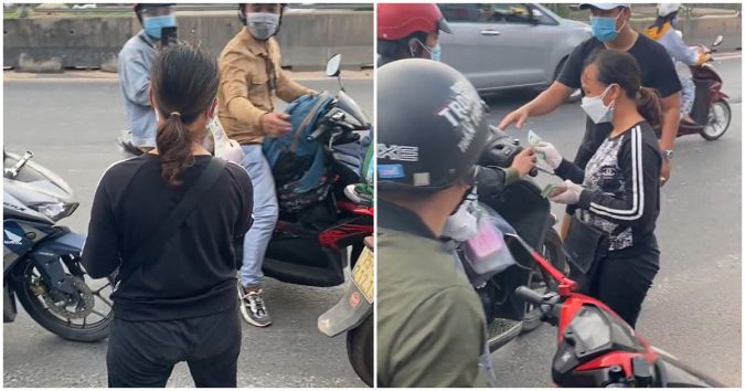 Xúc động hình ảnh người phụ nữ mang dép lê ôm cọc tiền 500k đứng trên quốc lộ 1A phát cho bà con về quê